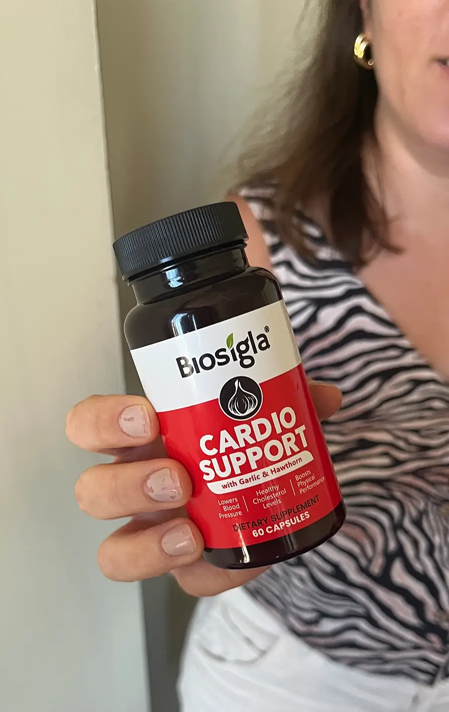 Woman holding a bag of Biosigla Cardio Support with colorful design elements.